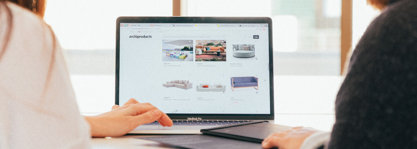 Two women are sitting behind the computer