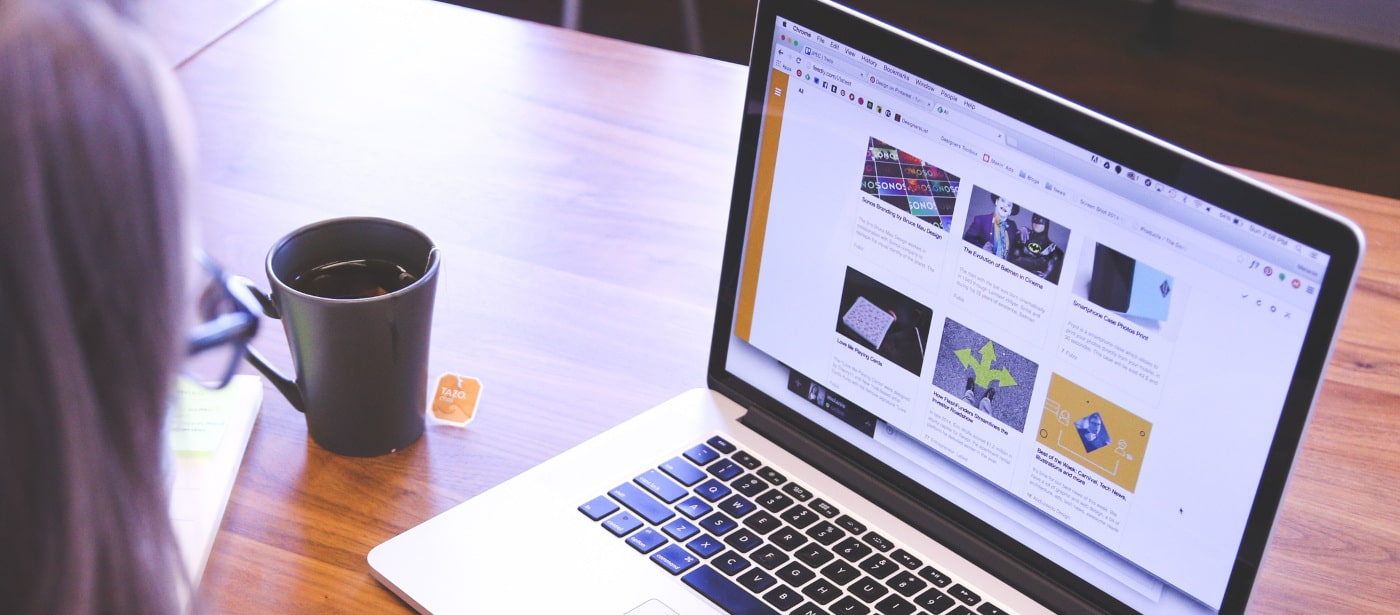 Woman drinking tea and loocking into the laptop screen