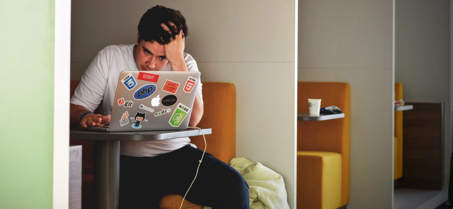 man wearing white top using MacBook