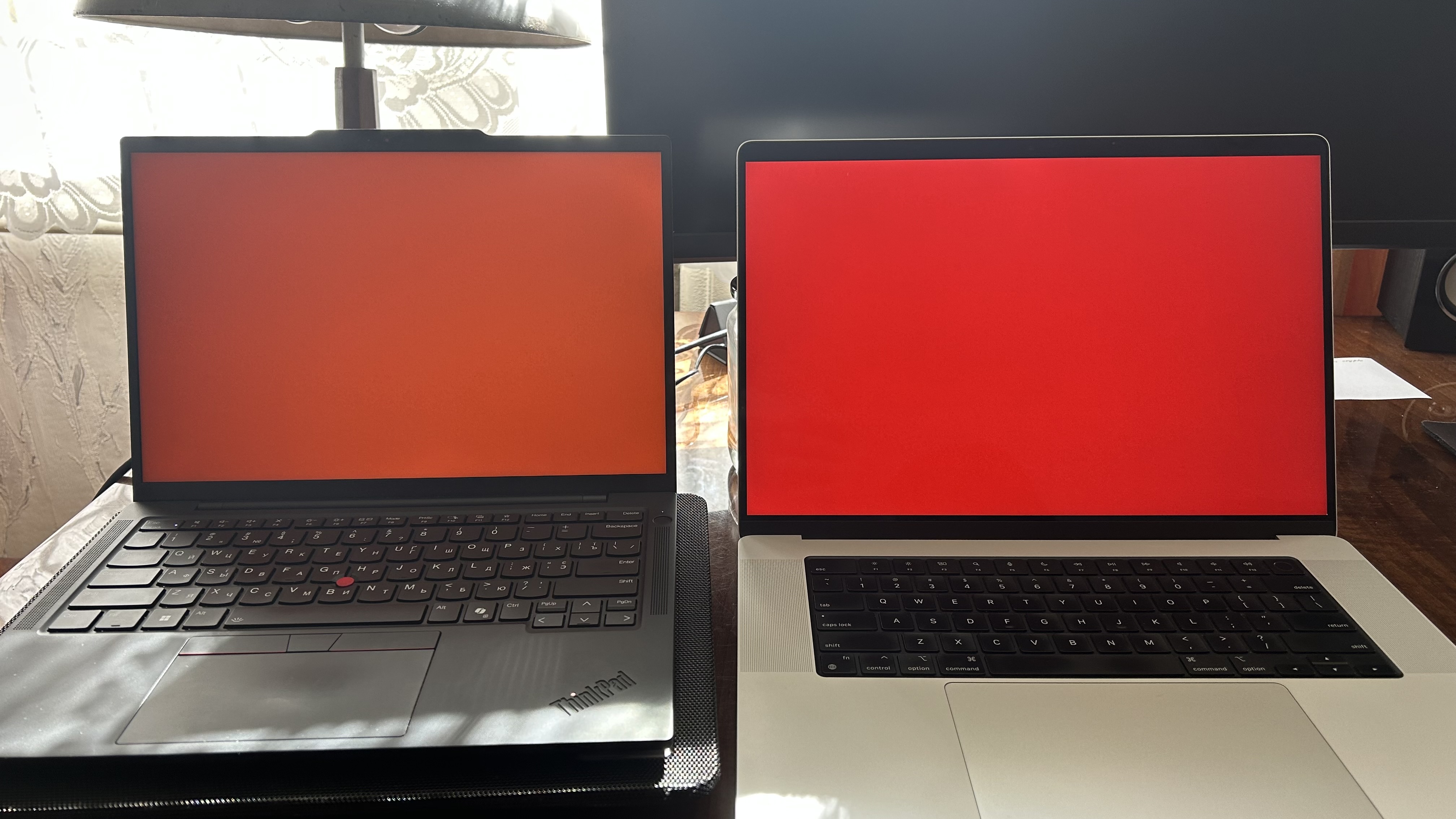 ThinkPad on the left and MacBook on the right with red screen